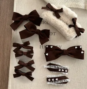 Flat lay of velvet brown bow hair clip set with lace and heart rhinestone details