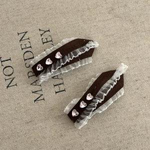 Close-up of retro brown velvet hair clips with white lace and pink heart rhinestones