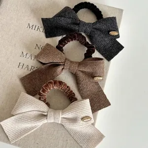 Three-piece set of French style bow hair ties in grey, brown and white ribbed fabric