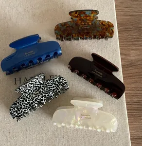 Detail showing five classic acetate hair claws in tortoise shell and pearl white finishes