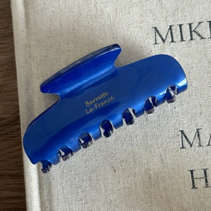 Close-up of a glossy deep blue acetate hair claw clip with gold Barrette La France text