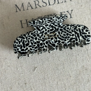 Detail of large acetate square hair claw with chic French leopard print and gold lettering