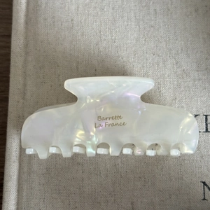 Detail of pearlescent white acetate hair claw clip with golden Barrette La France text