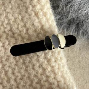 Elegant vintage enamel hair clip with black velvet finish and gold oval details