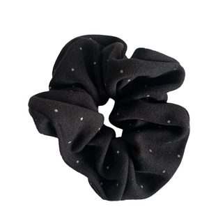 Minimalist black polka dot scrunchie with soft fabric texture for elegant hairstyling