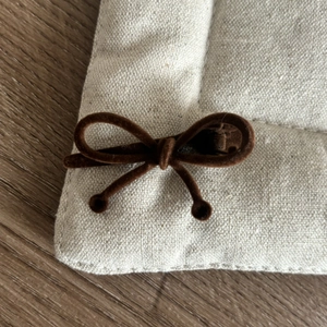 Barrette à cheveux nœud en velours marron avec perles sur présentoir en lin