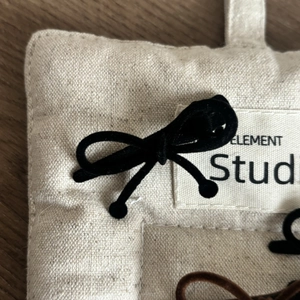 Détail de barrettes à nœuds en velours noir et marron avec perles sur surface texturée