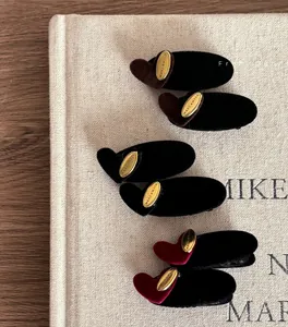 Detailed macro view of heart-shaped velvet hair clips with Makeawish golden metal plates