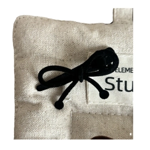 Pince à cheveux en lin beige avec nœud en velours noir et étiquette en tissu signée