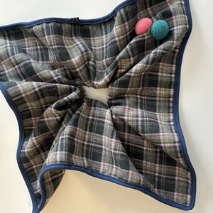 Detail of blue and pink plaid knit fabric with soft texture and handmade tag detail