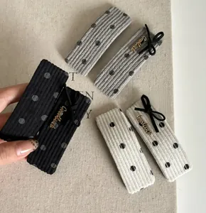 Détail de barrettes à cheveux en velours à pois avec lettrage Goodluck métallique