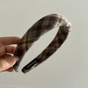 Detail of vintage plaid fabric headband showing handmade label and woven texture