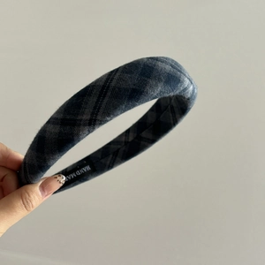 Detail of grey plaid wool headband featuring a high-quality handmade inner woven label