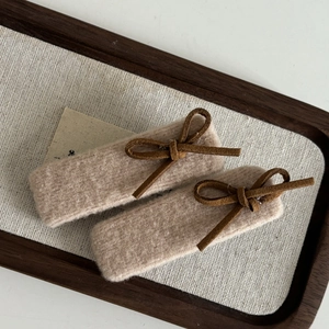 Beige Lammwolle Haarklammern Set mit Schleife im Vintage Design auf Leinen