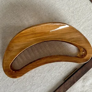 Retro semicircular hair claw clip with brown wood grain texture on linen background