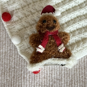 Close-up of plush gingerbread man Christmas hair clip with festive red and white details