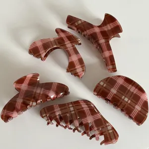 Detailed set of five vintage brown plaid hair claws with glossy finish on white surface