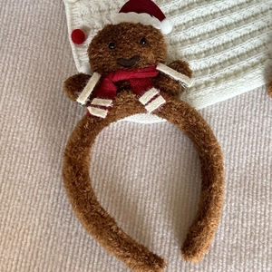 Detailed view of gingerbread man headband with plush material and festive red scarf