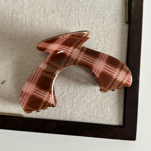 Close-up of a large arch hair claw clip featuring a vintage brown and pink plaid pattern
