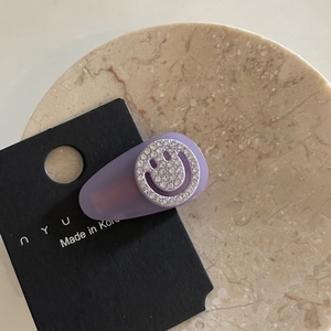 Purple frosted teardrop hair clip with a sparkling rhinestone smiley face on a card