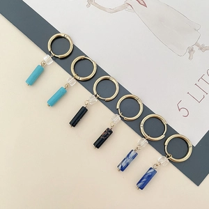 Three pairs of elegant gold hoop earrings with colorful crystal and stone charms