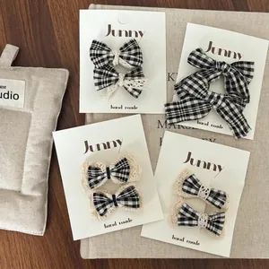 Lot de quatre barrettes à nœud vichy noir et blanc avec dentelle sur carte support