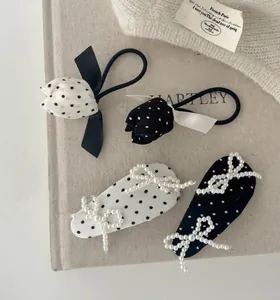 Gros plan détaillé de chouchous tulipe à pois et de barrettes à nœuds en perles