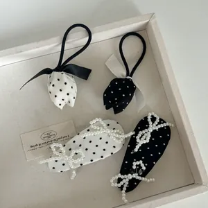 Détail de chouchous tulipes à pois et barrettes à cheveux avec perles et nœuds élégants