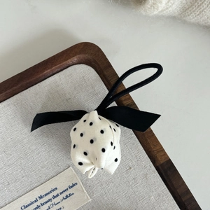 Chouchou tulipe à pois avec nœud en soie sur un plateau de bijoux en bois naturel