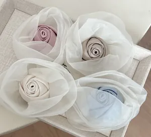 Detailed macro view of four pastel mesh rose hair clips in pink and white fabric