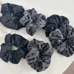 Flat lay set of six black and grey satin scrunchies with polka dot and heart embroidery