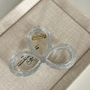 Close-up of glittery silver and black hair claw clip with golden metal spring detail