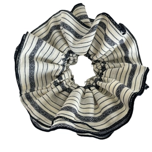 Striped oversized fabric scrunchie with geometric diamond pattern and black stitched edges