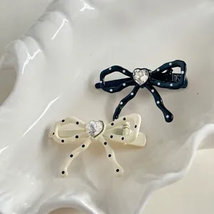 Sweet polka dot bow hair clips with heart-shaped rhinestones in black and cream