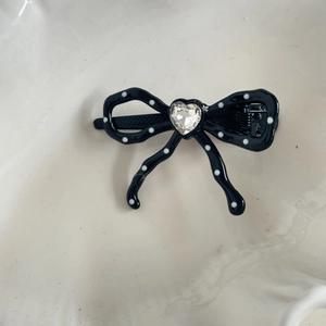 Sweet black and white polka dot bow hair clip with a sparkling heart rhinestone center