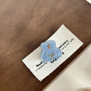 Vue détaillée de la pince à cheveux lapin bleu clair avec paillettes et visage souriant