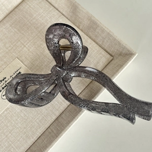 Sparkly dark gray bow hair claw clip with silver glitter finish for voluminous hair