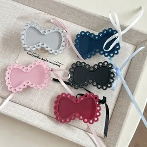 Detail of five colorful acrylic bow hair clips with silk ribbons on a fabric tray