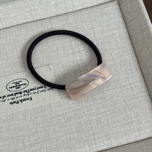 Detail of pink pearlescent acetate bead on black hair tie with France Handmade text