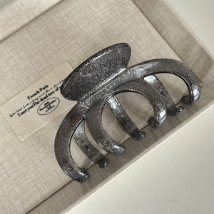 Macro detail of large dark grey glitter hair claw clip with a shimmering finish