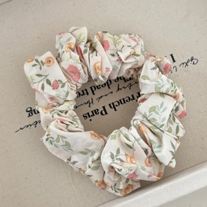 Gros plan d'un chouchou floral avec bordure en dentelle sur fond de toile de jute