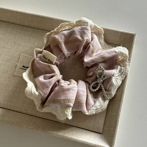 Gros plan détaillé d'un chouchou rose à rayures avec bordure en dentelle