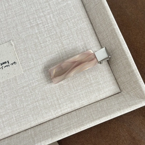 Detail of pink marble acetate hair clip with France Handmade engraving on silver metal