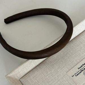 Detail view of thickened dark coffee satin headband with elegant sponge padding texture
