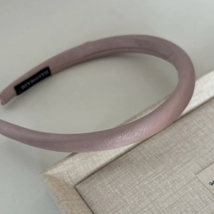 Detailed macro view of dusty pink sponge headband with handmade label and satin texture