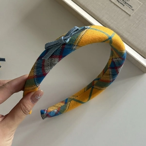 Detail of yellow checkered fabric headband with a small blue denim bow on the side