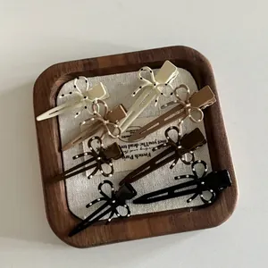 Dettaglio di cinque fermagli per capelli a fiocco in toni terra con motivi a pois