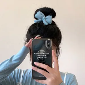 Chouchou nœud à rayures bleues sur chignon montré dans un selfie miroir élégant