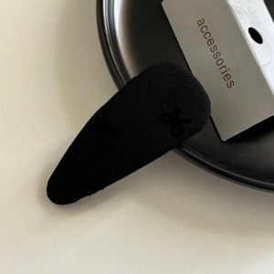 Elegante molletta BB nera testurizzata con fiocco dal design minimalista moderno