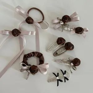 Detailed flat lay of brown rose hair accessories set with satin ribbons and pearls